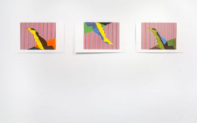 Three prints hung up horizontally with red and white stripes and a yellow, dark brown, orange shape on the bottom, the other two prints have the same shape, the print in the middle has the same shape but oriented upside down and it's blue and yellow and green, the print on the right has a green, dark green shape