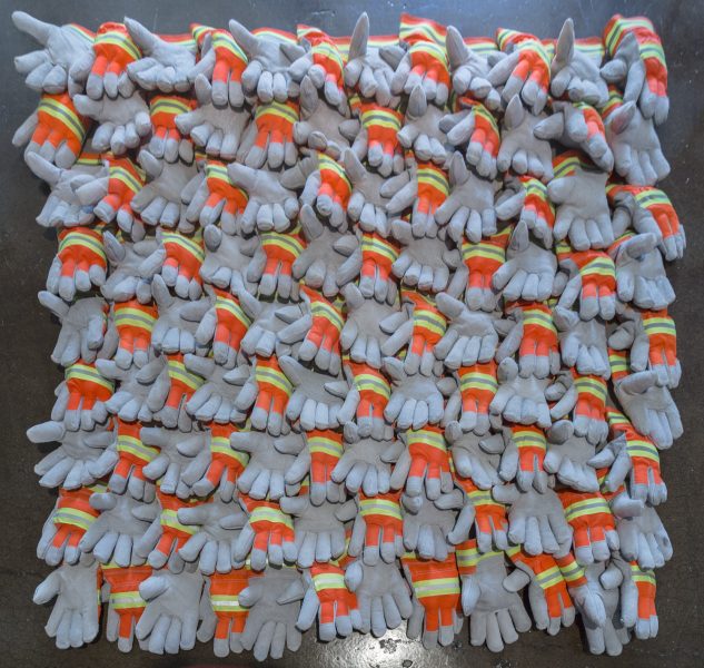 108 gray gloves placed next to each other forming a square, alternating between palm up and pam down, with neon orange on the top and neon yellow with reflective gray stripe