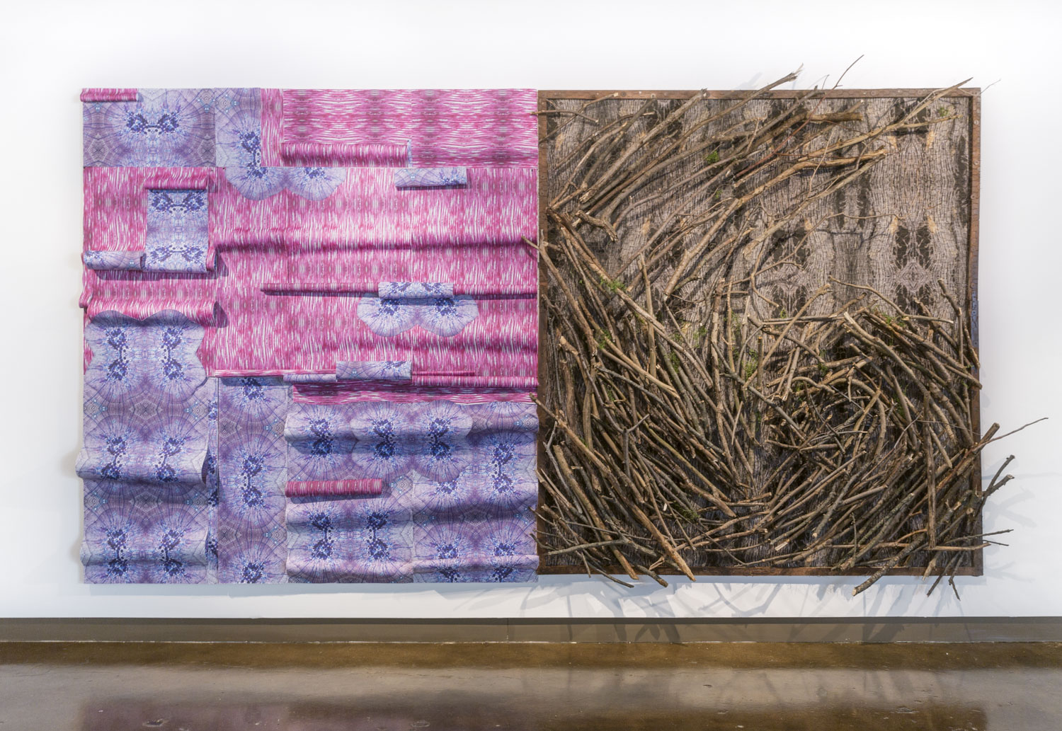 On the left is a purple and pink piece that looks like wall paper peeling off and layered, on the right is a piece that is made of a collection of tree branches on a brown textured background, both pieces are hung up on the wall right next to each other
