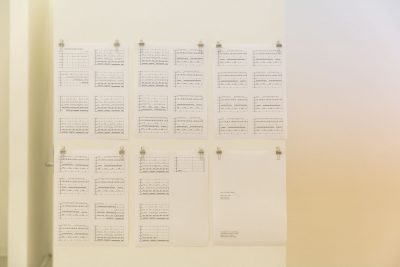 Six pieces of rectangular paper hung up by the two top corners with binder clips, in two rows of three, depicting horizontal bar graphs with various data filled in, the bottom right piece of paper displayed has text on the left side of the paper