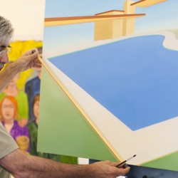 A man with earphones takes measurements of a pool line from a painting with a large pool and some green space on the bottom left and bottom right part of the image