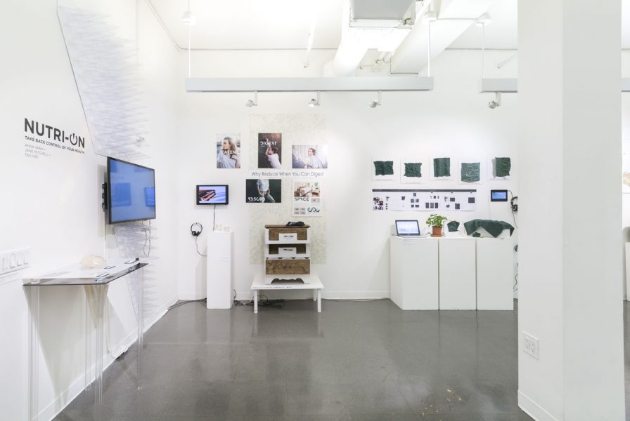 2017 BioDesign Challenge, Installation detail view, of television monitors and various artworks on pedestals.