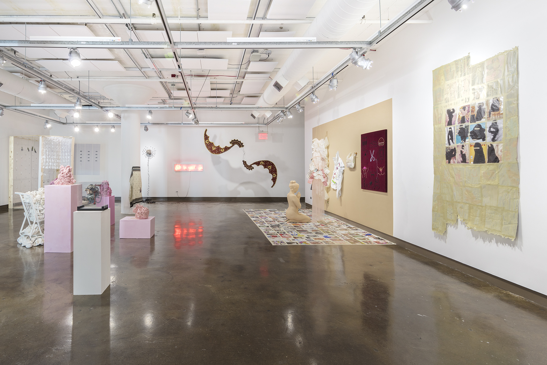 Installation view of the exhibiton titled "The Politics of Identity" at the SVA Chelsea Gallery. The view shows works of sculpture, painting, and mixed-media pieces spread throughout the room.