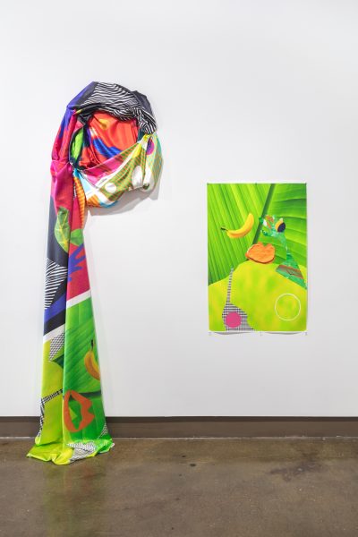 Installation view of bright collage c-print and a wall mounted 3D printed fabric rolled into a spiral that unravels onto the floor below