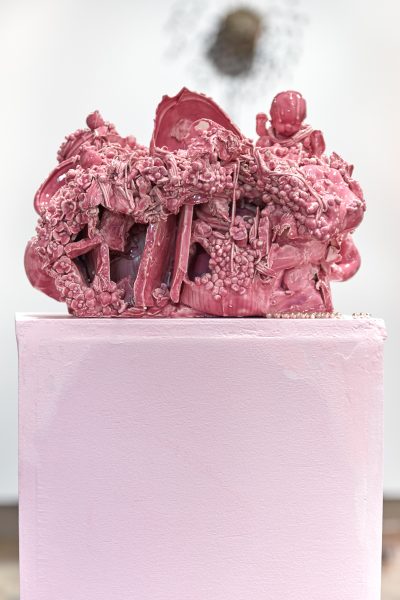 Detail of pink amorphous clay sculpture on a lighter shade of pink pedestal.
