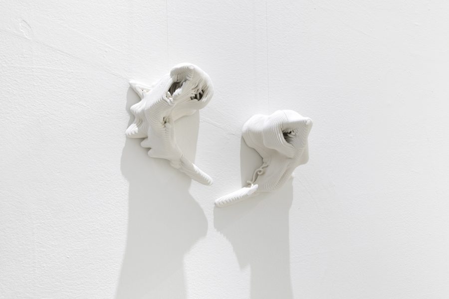 2 3d printed ceramic sculptures installed on a white wall