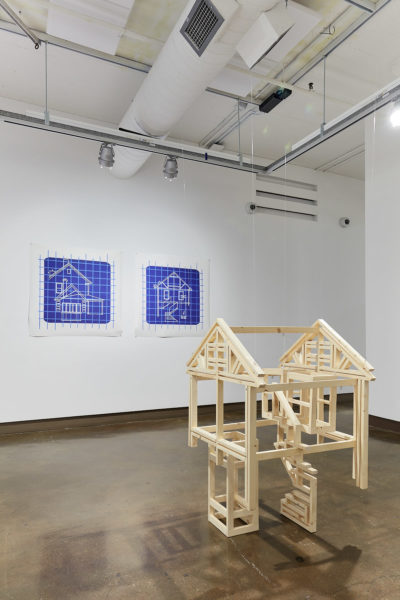 Exhibition Sticks and Stones May Break My Bones But Words Will never Hurt Me 2019. SVA Chelsea Galleries,New York. Artwork by Xiaoyu (Jade) Li. Wooden skeletal structure homes. Two architecture blueprints hanging from the wall.