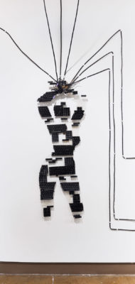 Exhibition Sticks and Stones May Break My Bones But Words Will never Hurt Me 2019. SVA Chelsea Galleries,New York. Artwork by Bethany Robinson. Multimedia Installation. A female figure with her hands above her head made out of computer keyboard.