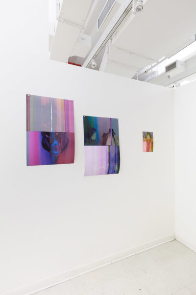 3 abstract photographs of varying sizes hang on a wall, spaced unevenly.