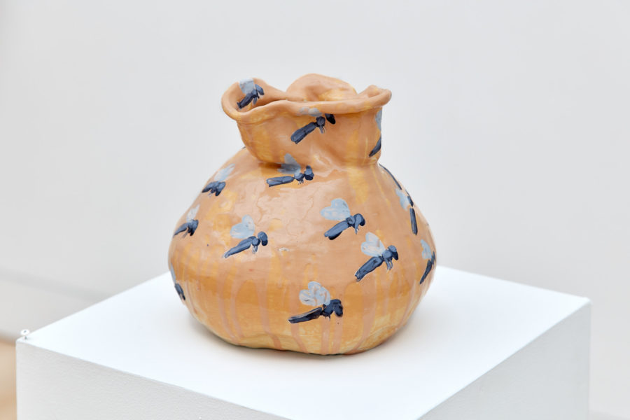 Exhibition "Tales and Whispers" 2019. SVA Flatiron Gallery, New York. A ceramic constructed bag glazed orange with an insect pattern.