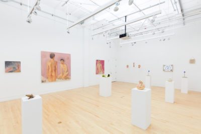 Exhibition Tales and Whispers 2019. SVA Flatiron Gallery, New York. Installation image featuring multiple paints of figures. In the center of the room there are  multiple sculptures placed on top of a pedestals.