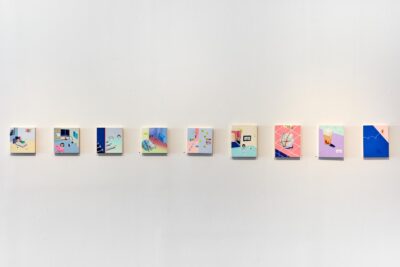 9 small colorful paintings installed in a row