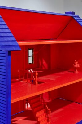 A doll house painted in saturated red and blue.