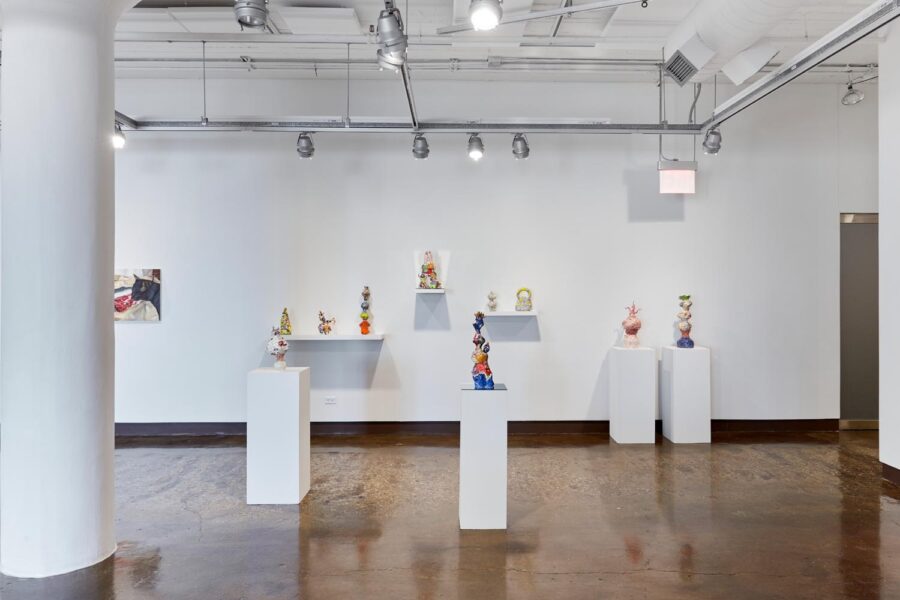 Ceramic pieces by Cao shown in a gallery. Four of the pieces are each on their own pedestal. The other pieces are sitting on a shelf in the back of the gallery.
