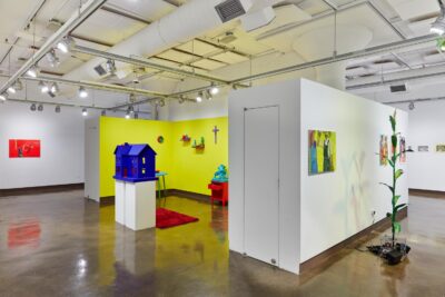 Installation view of vivid colored paintings on the wall and sculptures installed on the floor and the pedestal