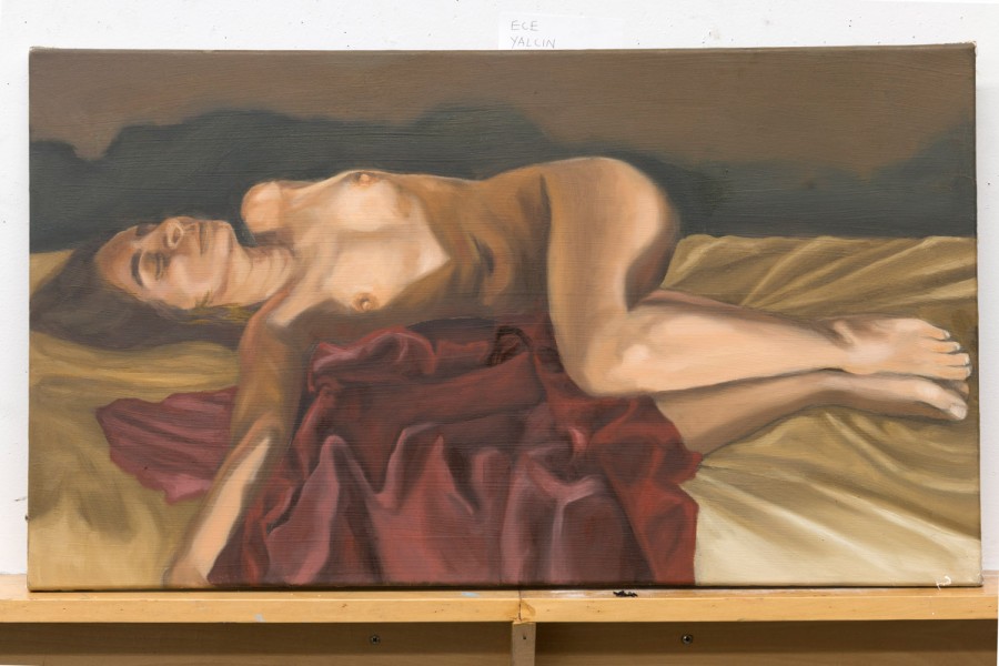 A nude painting of a woman laid on a bed with silky white sheets, a red silky bed cover, with her lower part of the body bent from the pelvis with knees bent. Her feet are illuminated, her knees and the bottom, the breasts, neck, and face are illuminated too, in a room with dim light