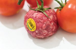 Poster for Biotech Future(s) with an illustration of tomatoes and one of them is made of meat with a yellow sticker on it