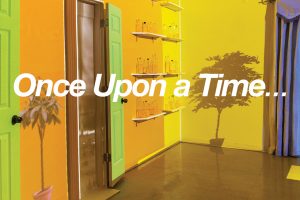 "Once Upon a Time..." is printed on the center of the poster, location and time information on the bottom left corner, the text is all white on a background of a roon with a palm tree, palm tree shadows, yellow walls, green doors, wall shelves with bottles, a brown floor and purple curtain on the left.