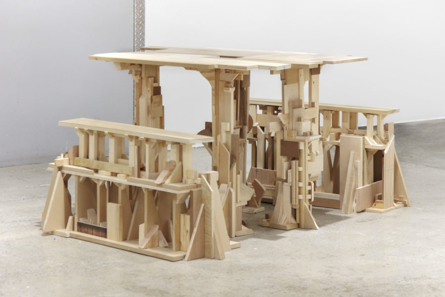 An assemblage of irregular pieces of lumber resembling a table and two benches. 