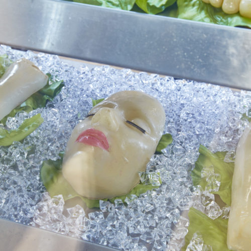 Detail of a simulation of a deli case with sculptures resembling body parts.