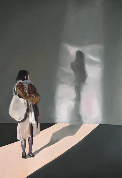 A woman looking back to her shadow in an art gallery.