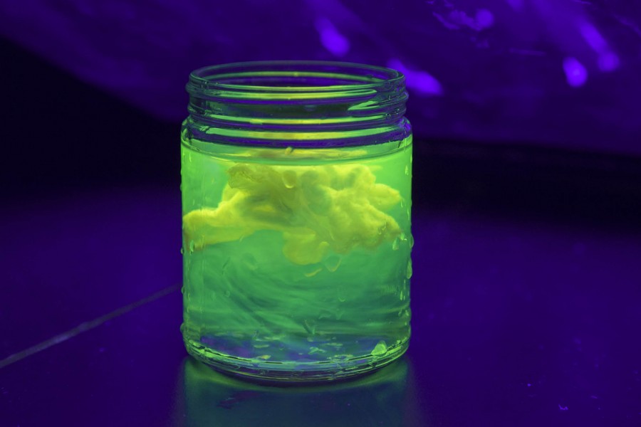 A close view of green fluorescent bacteria in a jar under UV light Bio Lab. SVA BFA Fine Arts