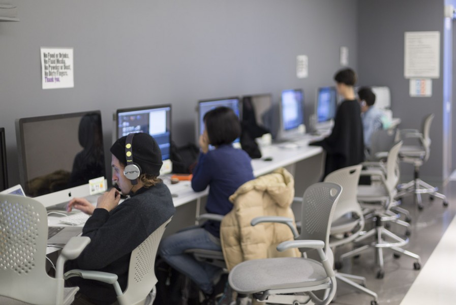 Students are sitting at desks and working on the computer.