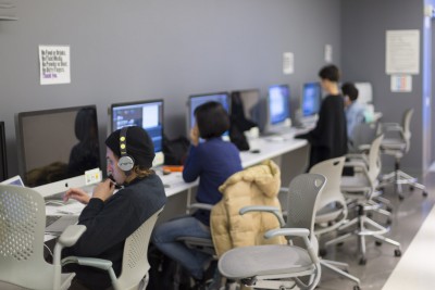 Overview of a class with students sitting at their desks working on iMacs