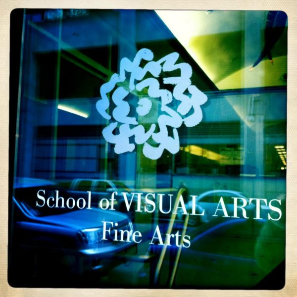 SVA BFA Fine Arts - School of Visual Arts New York. the logo is on a glass surface reflecting the street and the cars with blue and green light