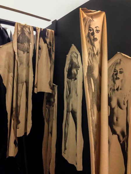 Installation view of nude women printed on gold silk fabric.