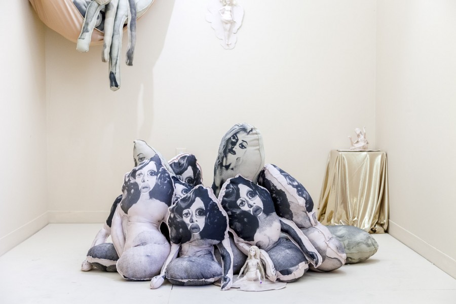 Installation view of pillows with prints of nude women.