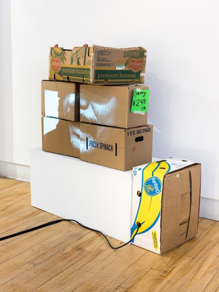 A sculpture by Alize Santana. Cardboard boxes sitting on a wooden floor. 