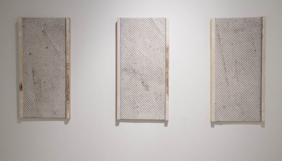 A view of three rectangular paintings with ribbed texture in a light grey color with wooden rails on the left and right of each individual painting