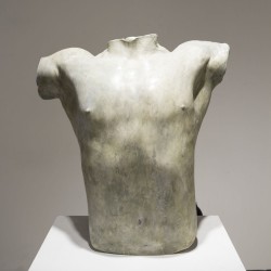 Bust sculpture made of white-grey material of a male body without the head and the hands