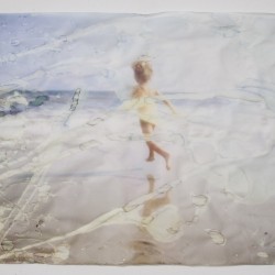 A print of a little girl running on the beach and dried water drops alter the print