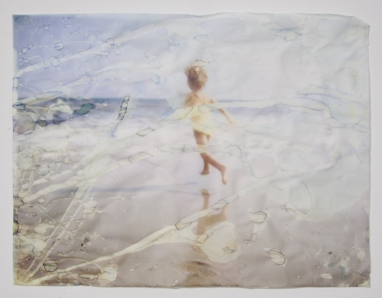 A print of a little girl running on the beach and dried water drops alter the print