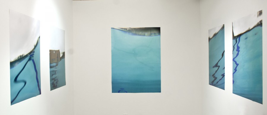 Exhibition view of prints with water reflections of different materials, lines, and shapes