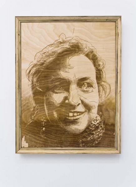 A portrait on the wood surface in a wooden frame of a person with some hair on the forehead and a scarf on the neck 