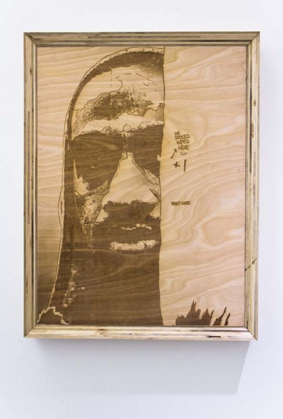 Portrait of a person on a wood piece in a wooden frame, representing a man's face with long hair and eyes in the shadow, and the right part of the painting is blank with the face cut