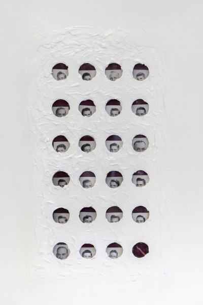 A grid of black and white circular school portraits, partly covered with white paint.