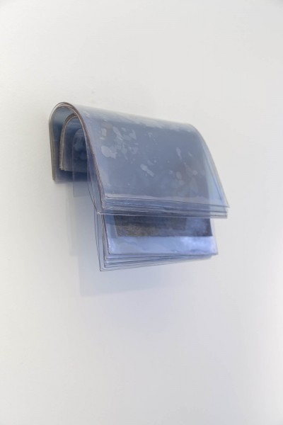 Multiple plastic sheets with magazine covers hanging from the wall.
