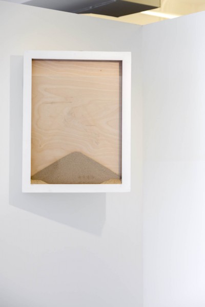 A rectangle shaped frame with a glass front and a pile of sand forming a triangle by Daniel Fairbanks