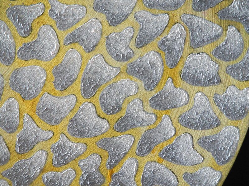 An abstract painting of irregular gray shapes on a yellow ground.