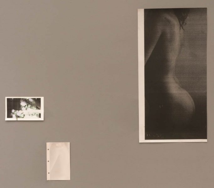 Three black and white prints are installed on a wall, two representing a nude woman side back and bottom, from which one is almost white with the contrast reversed, and the last one is abstract with light spots, and rounded shapes