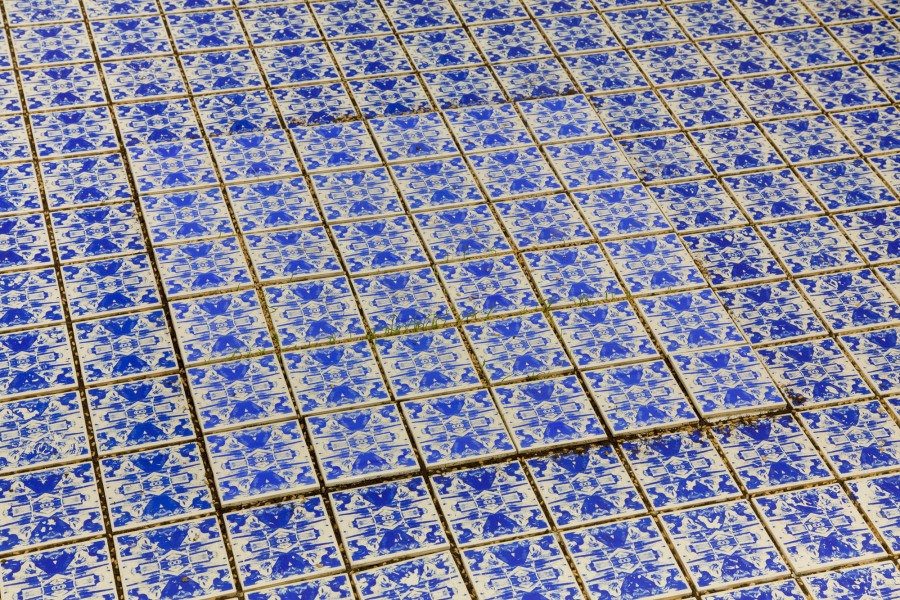 Ceramic tails lay down in a pattern with abstract blue shapes on each tile