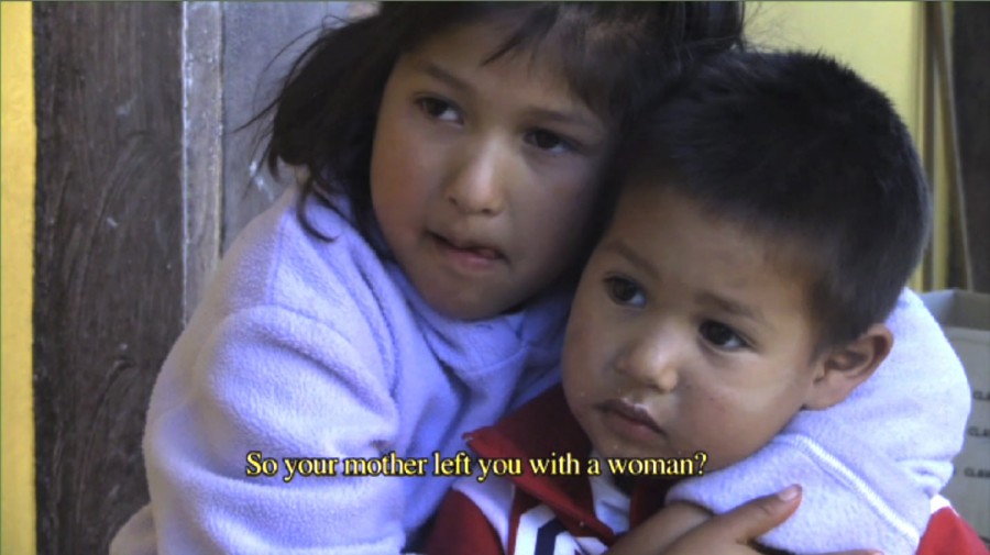 Screen capture from a clip of two children looking at the person asking the question and a caption: So your mother left you with a woman?