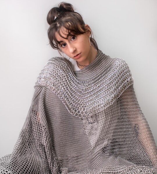 Emma Fasciolo portrait wearing chainmail blanket.