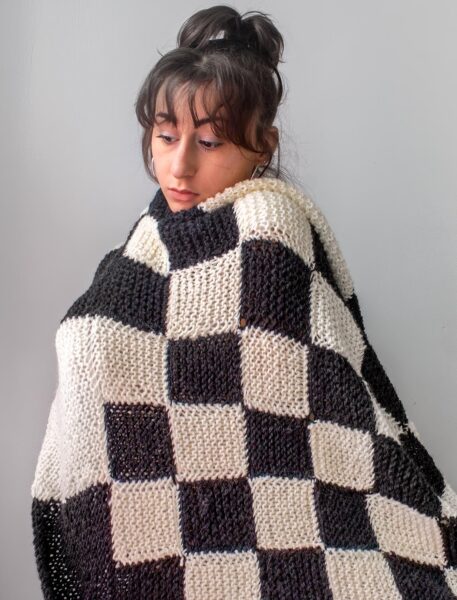 Emma Fasciolo wearing black and white checkered blanket.