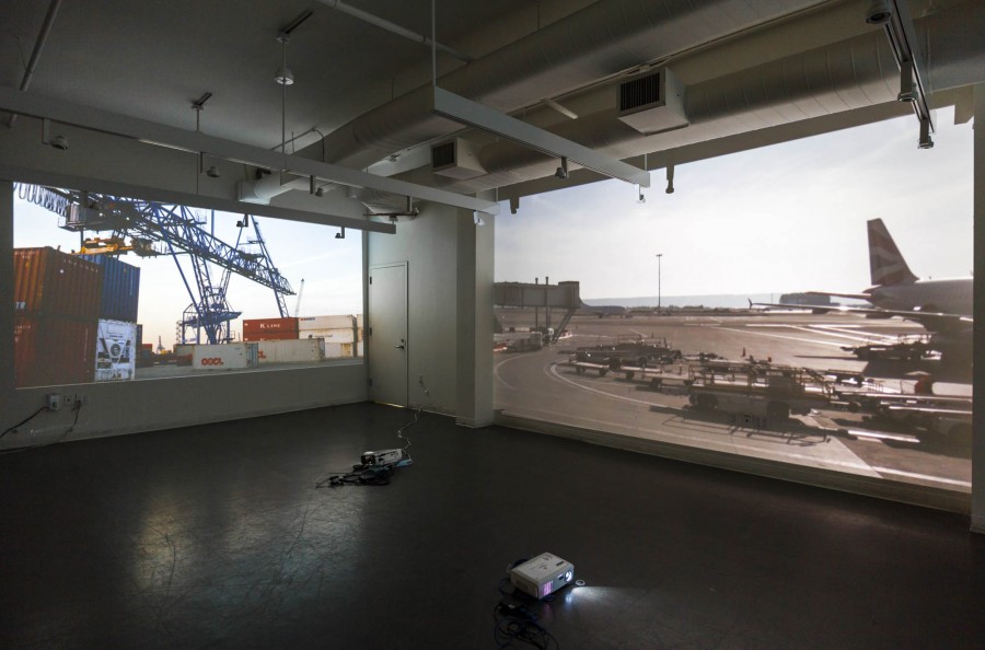 Installation view of two image projectors projecting different images from "Europe's Ice core Sampling" of an industrial place on the background wall and an airport view with the tail of a commercial airplane on the right sidewall.