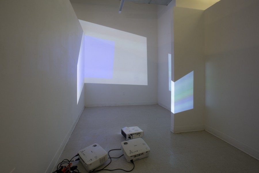 Installation view of image projectors projecting horizontal line images on the corners of the room and the wall.